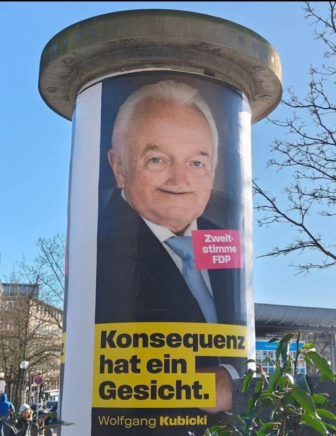 Litfass mit zu eng gegeneinander verklebten Kubicki-Wahlplakatteilen. Er sieht noch drolliger aus als sonst.