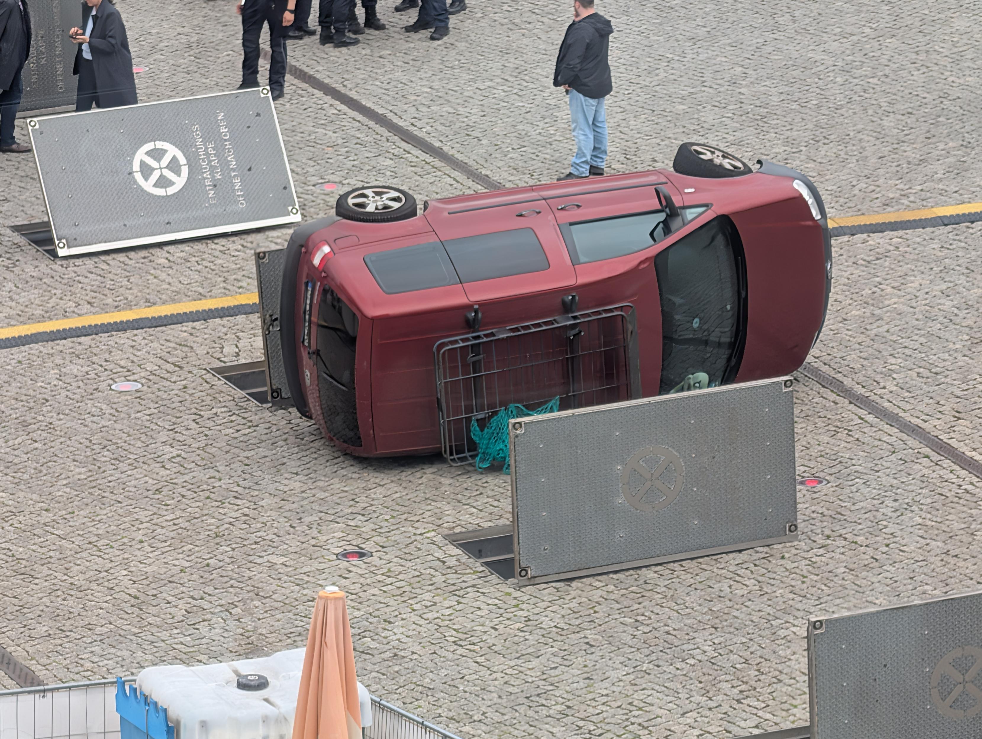 Geöffnete Entrauchungsklappen, dazwischen ein auf der Seite liegendes Auto.